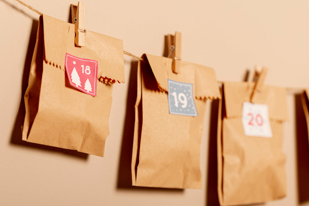 Selbst gefüllter Adventskalender aus kleinen Papiertüten an einer Wand