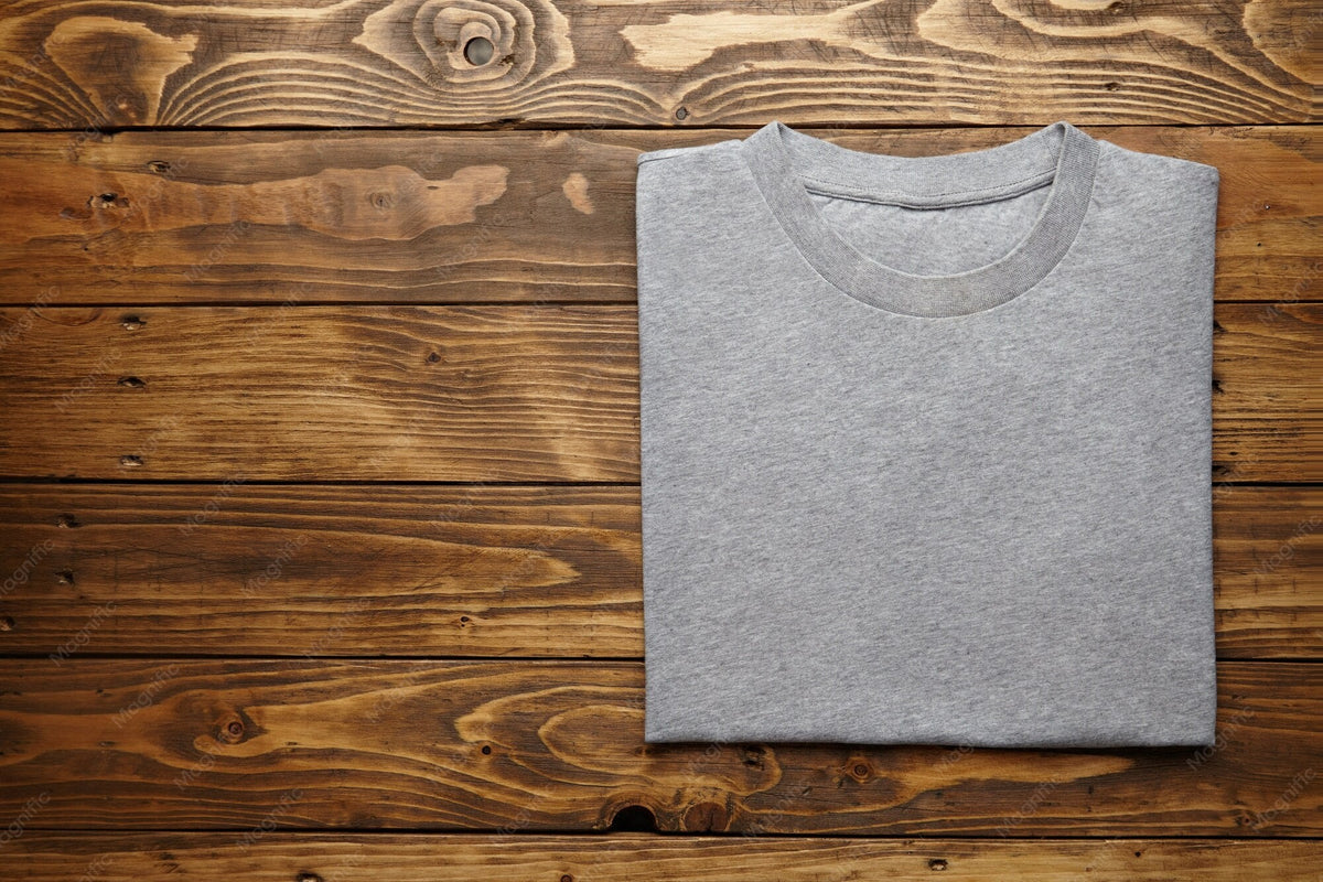 Ordentlich gefaltetes graues T-Shirt auf einem Holztisch